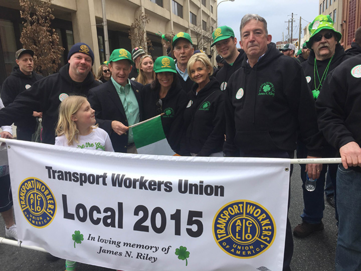 Local 2015 members at the parade in front of a banner honoring James Riley