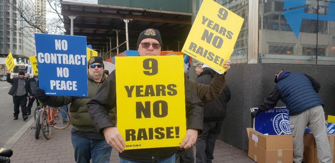 A group of people holding a sign Description automatically generated